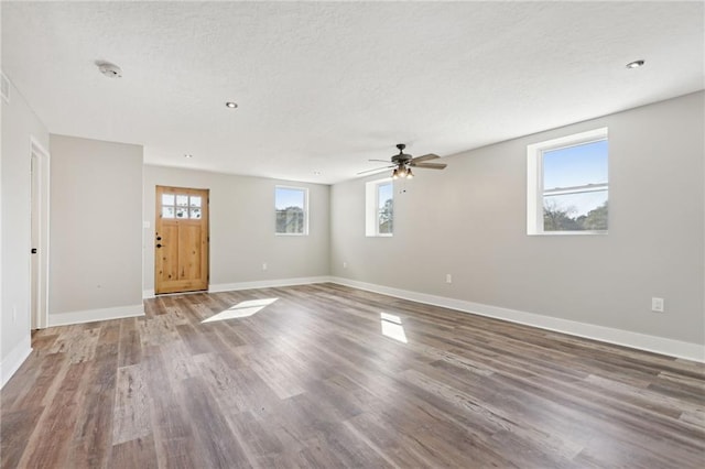 unfurnished room with hardwood / wood-style flooring, plenty of natural light, and a textured ceiling