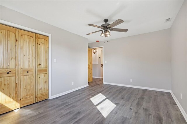 unfurnished bedroom featuring a closet, ceiling fan, and dark hardwood / wood-style flooring