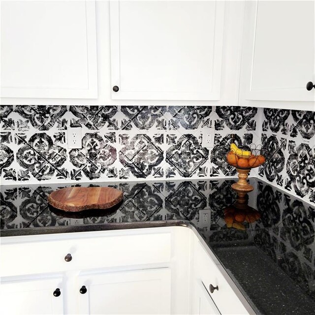 kitchen with white cabinets, decorative backsplash, and dark stone countertops