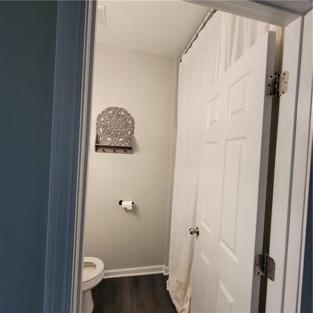 bathroom with hardwood / wood-style floors and toilet