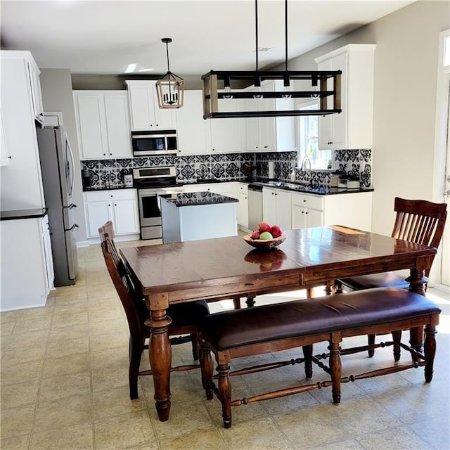 kitchen featuring backsplash, a center island, stainless steel appliances, and hanging light fixtures