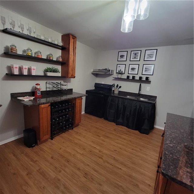 kitchen featuring black range with electric stovetop, sink, and light hardwood / wood-style flooring