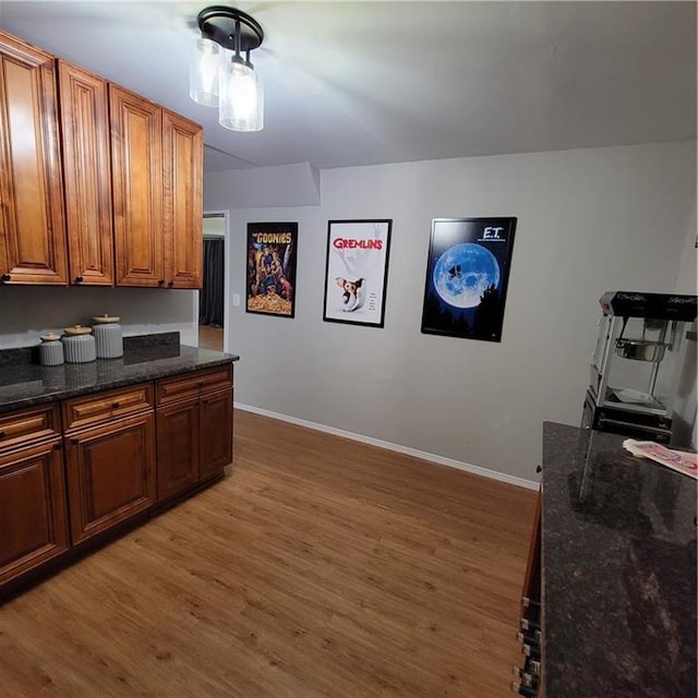 kitchen with dark stone countertops and hardwood / wood-style flooring