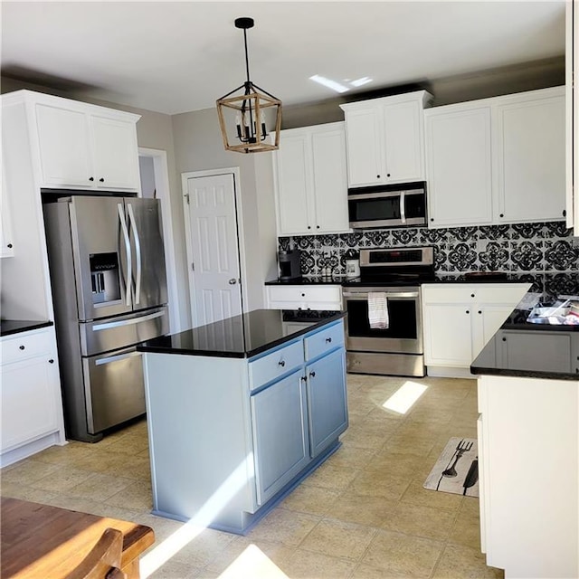 kitchen featuring white cabinets, stainless steel appliances, and hanging light fixtures