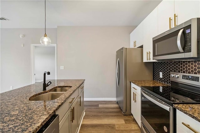 898 Oak St SW Unit 3228, Atlanta, GA 30310 - kitchen with appliances with stainless steel finishes, dark wood-style floors, backsplash, dark stone countertops, and hanging light fixtures