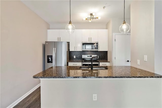 898 Oak St SW Unit 3228, Atlanta, GA 30310 - kitchen featuring stainless steel appliances, backsplash, dark wood-style floors, dark stone countertops, and a peninsula