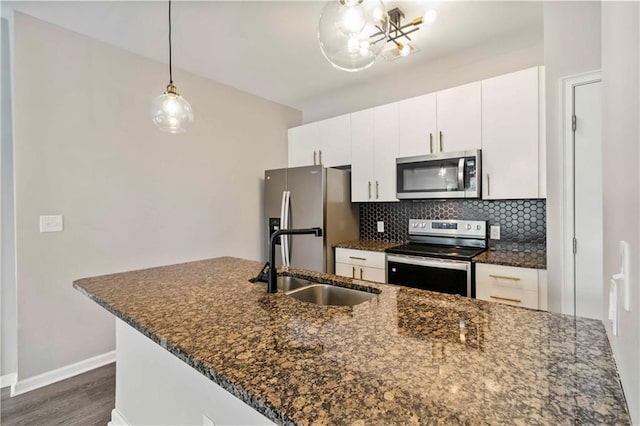 898 Oak St SW Unit 3228, Atlanta, GA 30310 - kitchen with stainless steel appliances, tasteful backsplash, white cabinetry, dark wood finished floors, and decorative light fixtures