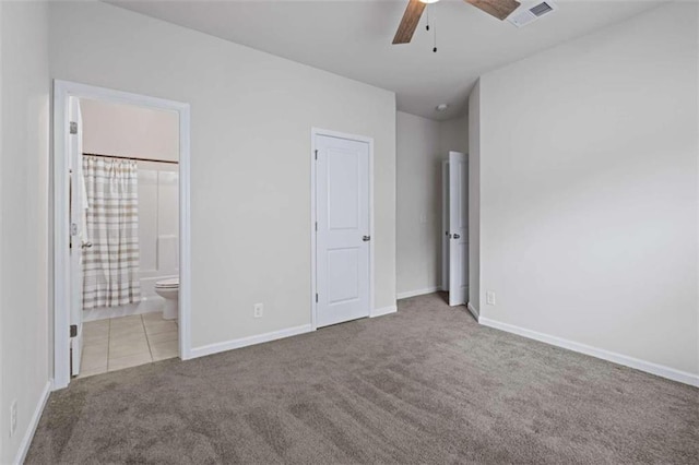 unfurnished bedroom with ensuite bath, carpet, and ceiling fan