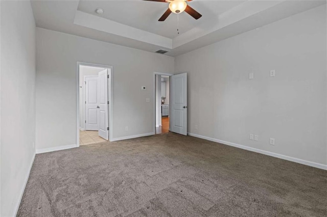 unfurnished bedroom featuring light tile patterned floors, ceiling fan, and a raised ceiling