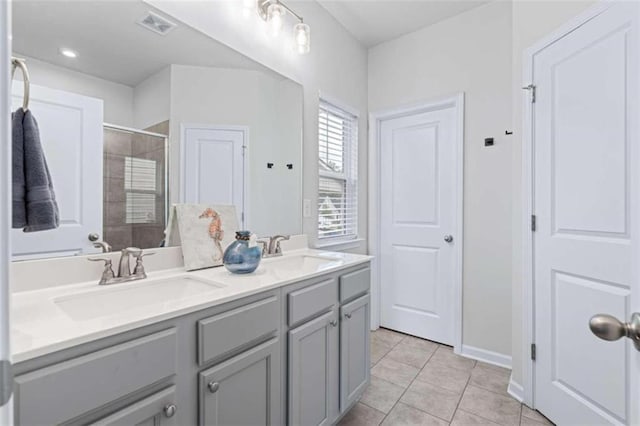 bathroom with tile patterned floors and dual bowl vanity