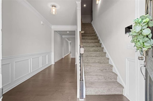 stairs with dark hardwood / wood-style flooring and ornamental molding