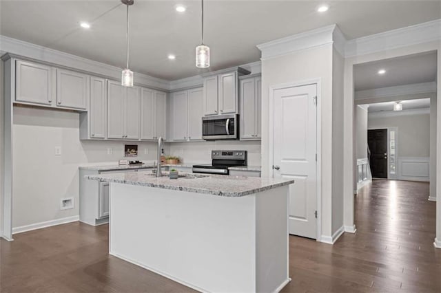 kitchen with stainless steel appliances, dark hardwood / wood-style flooring, sink, light stone countertops, and a kitchen island with sink