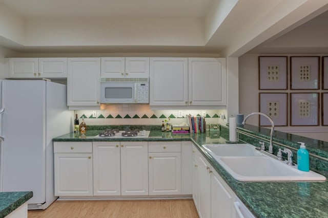 3636 Habersham Rd Unit 2307, Atlanta, GA 30305 - kitchen with white appliances, decorative backsplash, white cabinets, dark countertops, and a sink