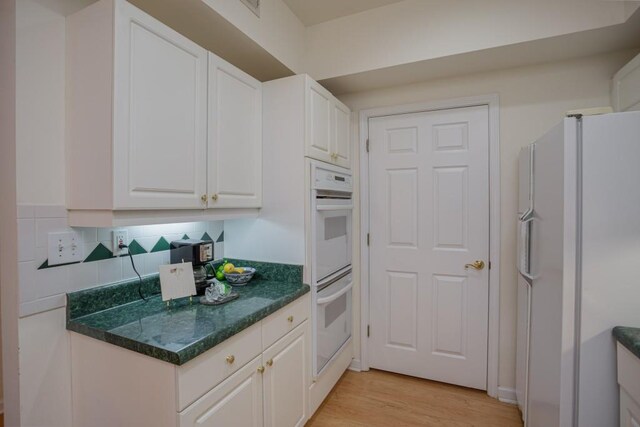 3636 Habersham Rd Unit 2307, Atlanta, GA 30305 - kitchen with tasteful backsplash, white appliances, white cabinetry, and light wood-style flooring