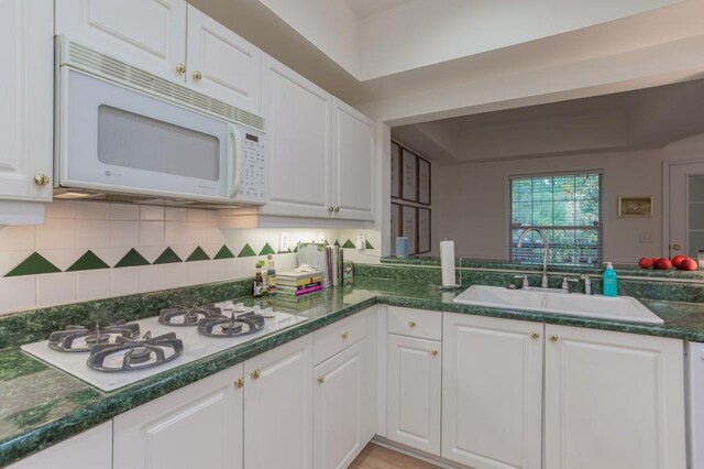 3636 Habersham Rd Unit 2307, Atlanta, GA 30305 - kitchen featuring white appliances, tasteful backsplash, white cabinets, and a sink