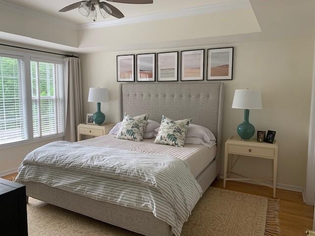 3636 Habersham Rd Unit 2307, Atlanta, GA 30305 - bedroom featuring baseboards, a tray ceiling, wood finished floors, and crown molding