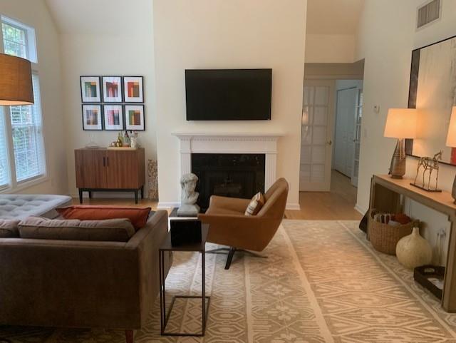 3636 Habersham Rd Unit 2307, Atlanta, GA 30305 - living area with vaulted ceiling, a fireplace, and visible vents