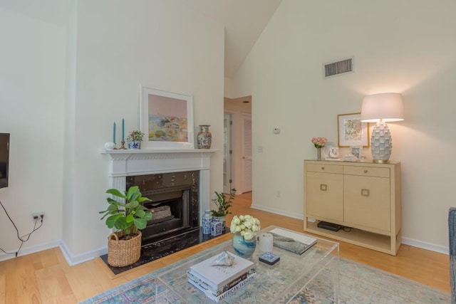 3636 Habersham Rd Unit 2307, Atlanta, GA 30305 - living area with high vaulted ceiling, wood finished floors, a high end fireplace, visible vents, and baseboards