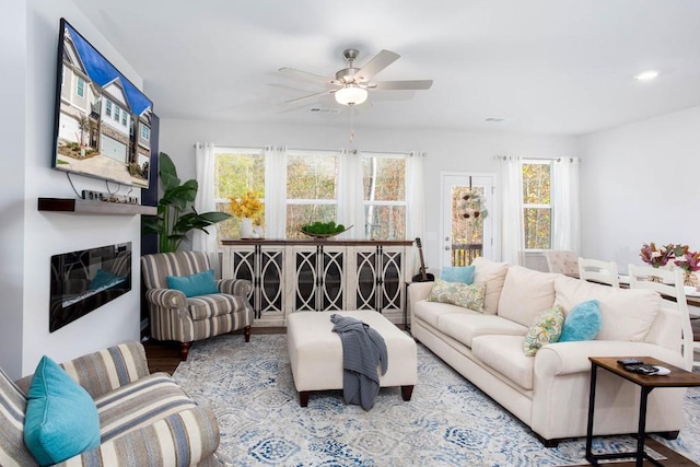 living room with plenty of natural light, ceiling fan, and light wood-type flooring