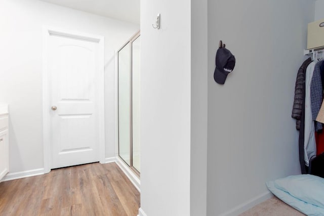 bathroom with wood-type flooring and a shower with door