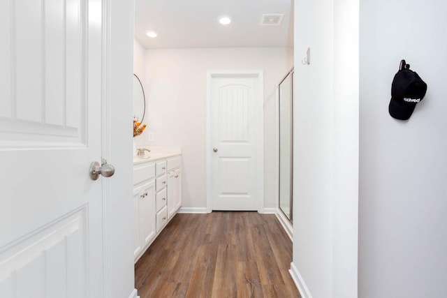 bathroom with vanity, a shower with shower door, and hardwood / wood-style flooring