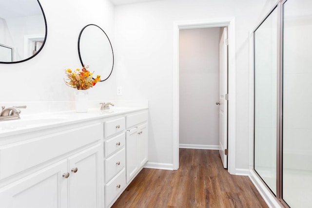 bathroom with wood-type flooring, vanity, and an enclosed shower