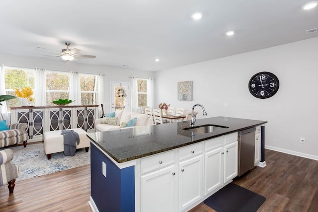 kitchen featuring white cabinetry, sink, dishwasher, dark wood-type flooring, and an island with sink