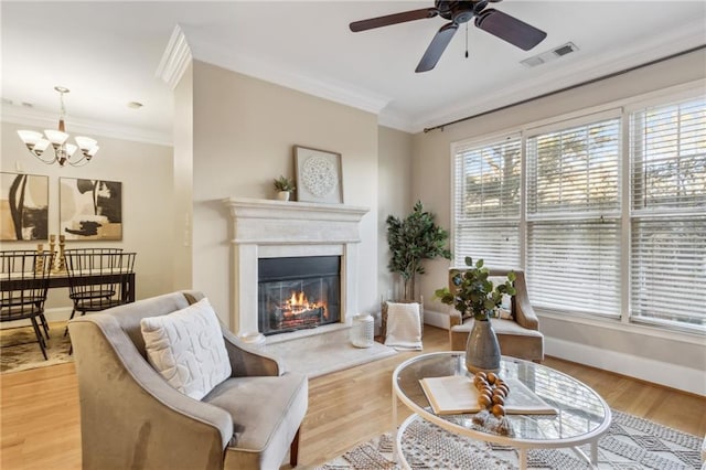 living area with light wood finished floors, visible vents, and ornamental molding