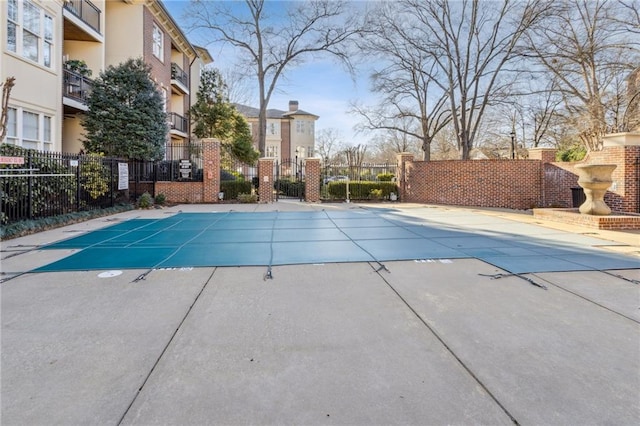 pool with a patio area and fence