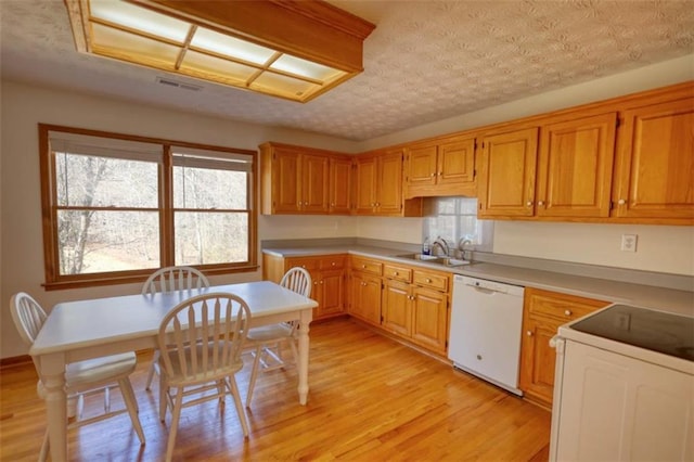 kitchen with a textured ceiling, sink, light hardwood / wood-style floors, and white appliances