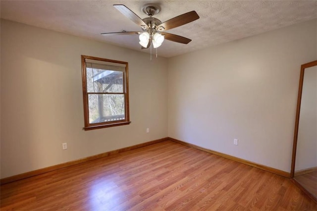 empty room with ceiling fan, a textured ceiling, and light hardwood / wood-style floors