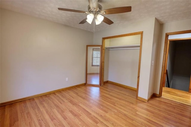 unfurnished bedroom featuring ceiling fan, a closet, a textured ceiling, and light hardwood / wood-style flooring