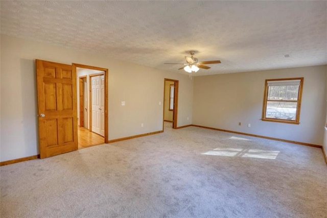 carpeted spare room with ceiling fan and a textured ceiling