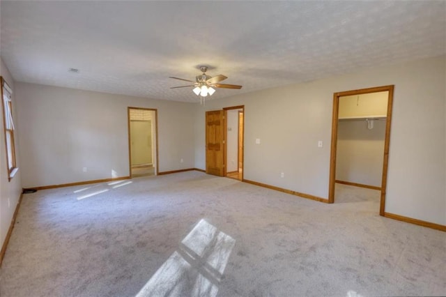 empty room featuring ceiling fan, a textured ceiling, and light carpet