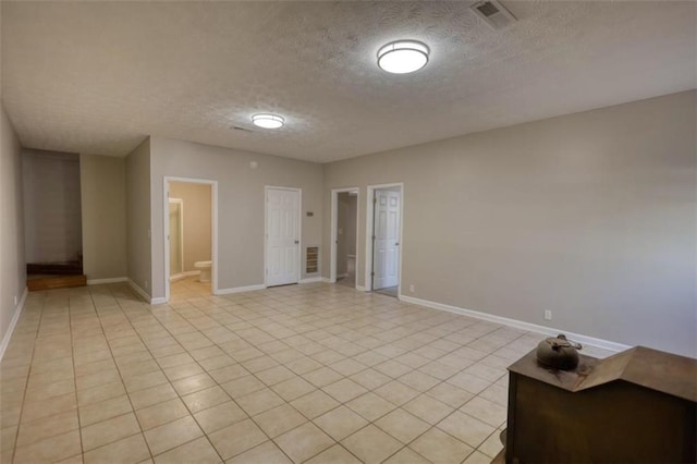 spare room featuring light tile patterned floors and a textured ceiling