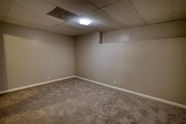 basement with carpet and a paneled ceiling