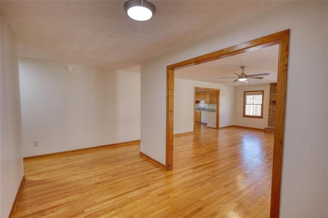 spare room featuring ceiling fan, a textured ceiling, and light hardwood / wood-style flooring