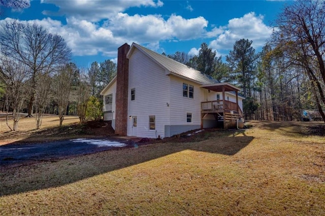 view of side of home featuring a deck and a lawn