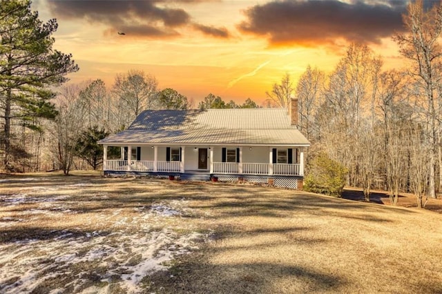 farmhouse-style home with covered porch and a yard