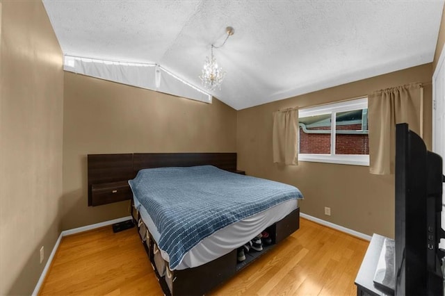 1822 N Rock Springs Rd NE Unit 24, Atlanta, GA 30324 - bedroom with lofted ceiling, light wood-style flooring, a textured ceiling, and a chandelier