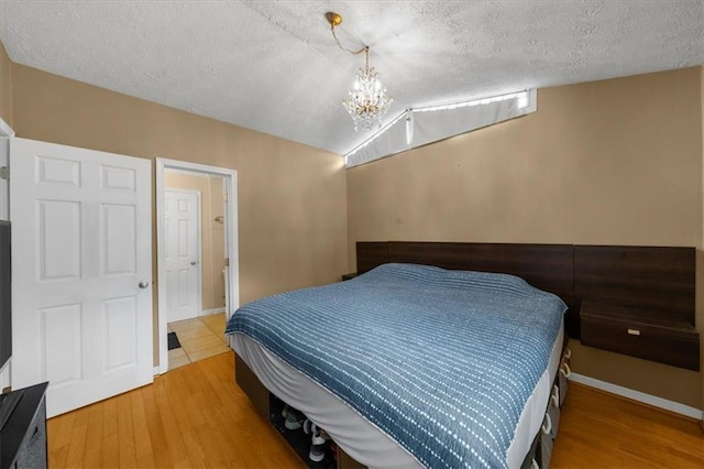 1822 N Rock Springs Rd NE Unit 24, Atlanta, GA 30324 - bedroom with wood finished floors, a textured ceiling, and a chandelier