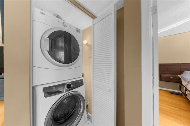 1822 N Rock Springs Rd NE Unit 24, Atlanta, GA 30324 - washroom with stacked washer and clothes dryer and wood finished floors