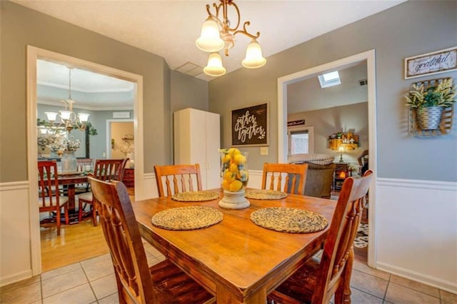 dining room featuring light tile patterned flooring and a notable chandelier