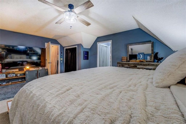 carpeted bedroom with a textured ceiling, vaulted ceiling, and ceiling fan