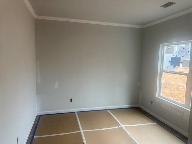 spare room with ornamental molding, visible vents, and baseboards