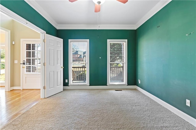 unfurnished room featuring ceiling fan, light colored carpet, and crown molding