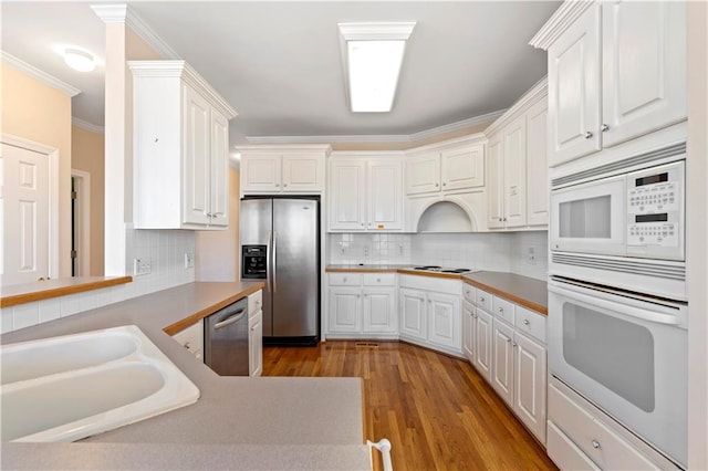 kitchen featuring decorative backsplash, white cabinetry, sink, and appliances with stainless steel finishes