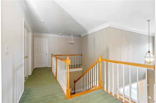 corridor with carpet flooring, ornamental molding, and a chandelier