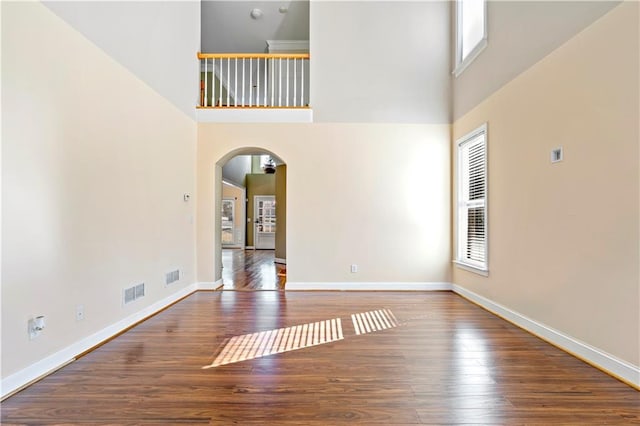 empty room featuring hardwood / wood-style flooring and a high ceiling