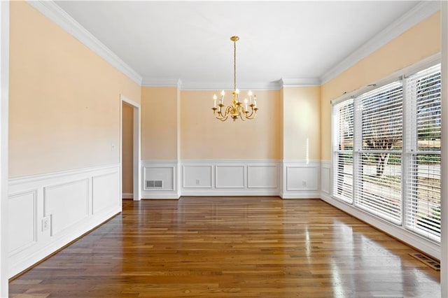 unfurnished dining area featuring a notable chandelier, dark hardwood / wood-style flooring, and ornamental molding